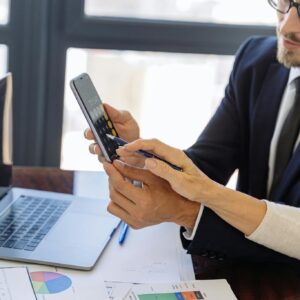 Man in Black Suit Holding a Black Smartphone